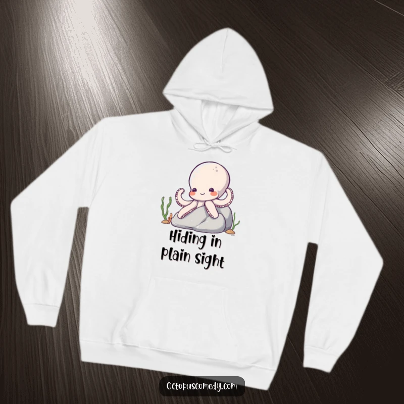 Funny Octopus Hoodie: A shy, smiling octopus peeking from behind a rock, its multiple arms gently waving hello.